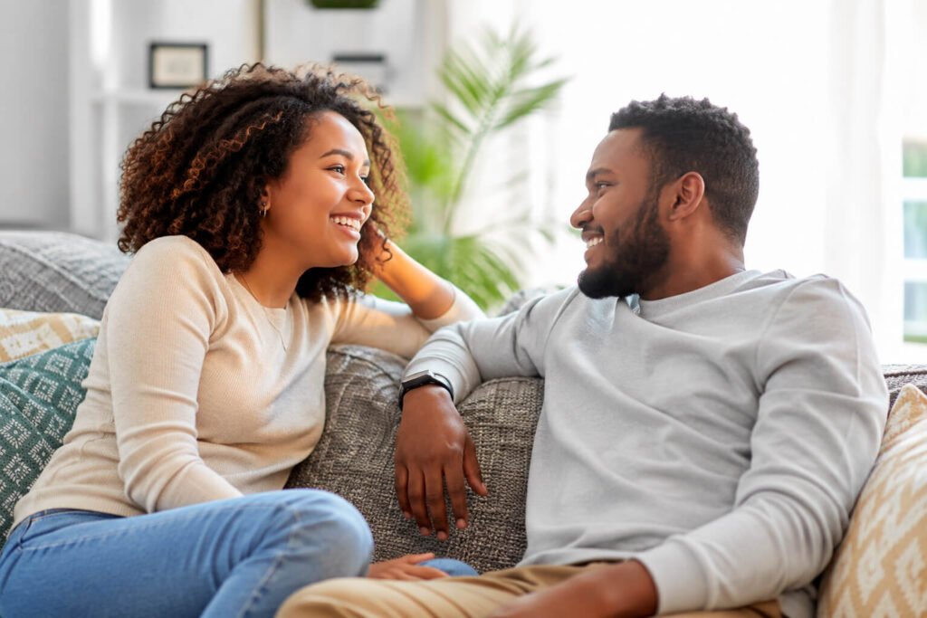 Smiling couple sitting together on a couch.